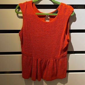 The orange sleeveless top with a peplum finish on the bottom and keyhole bac
